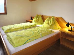 1 Schlafzimmer mit 2 Betten und gelben Daunendecken in der Unterkunft Holiday Home Auer - EBE115 by Interhome in Eben im Pongau