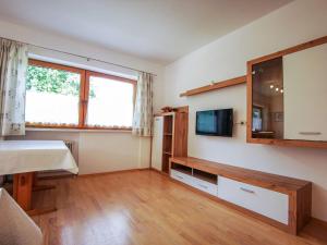 ein Wohnzimmer mit einem TV und einem Tisch in der Unterkunft Holiday Home Kainer - FGZ210 by Interhome in Strass im Zillertal