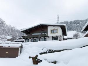 a house covered in snow at Apartment Höllwarth by Interhome in Fügenberg