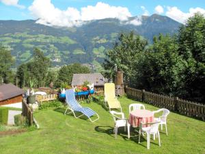 a group of chairs and a table in the grass at Apartment Höllwarth by Interhome in Fügenberg