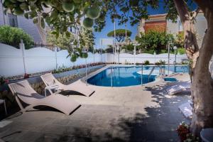 basen z 2 krzesłami i drzewem w obiekcie Hotel La Pergola w mieście Sant'Agnello