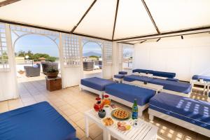 patio z niebieskimi krzesłami i stołem z jedzeniem w obiekcie Hotel La Pergola w mieście Sant'Agnello