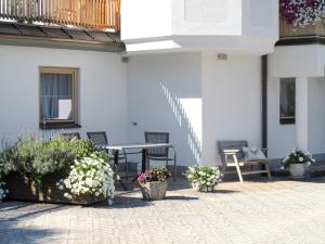 patio ze stołem, krzesłami i kwiatami w obiekcie Apartment Kohler by Interhome w mieście Fügen
