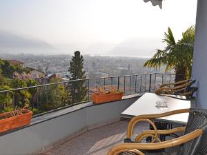 uma varanda com uma mesa e cadeiras e uma vista em Apartment Suite Modern-17 by Interhome em Ascona