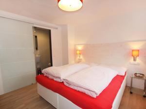 a bedroom with a bed with white and red sheets at Chalet Dr-Steiner by Interhome in Zell am See +29 photos