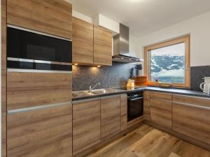 kuchnia z drewnianymi szafkami i oknem w obiekcie Apartment Apart Wurm-1 by Interhome w mieście Stummerberg