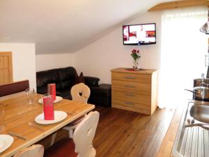 cocina y sala de estar con mesa de madera y sillas en Apartment Klammlhof - ZAZ307 by Interhome en Zell am Ziller