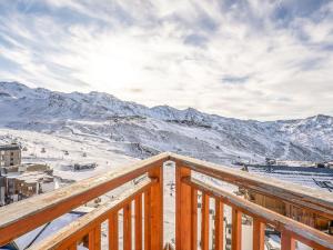 a view of a snowy mountain from a wooden deck at Apartment Les Trois Vallées-1 by Interhome in Val Thorens