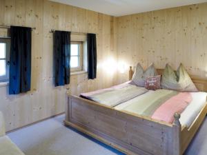 a bedroom with a bed in a room with wooden walls at Chalet Alm Chalet by Interhome in Gattererberg