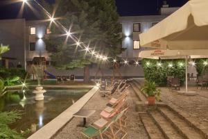 a hotel with a pool with chairs and lights at Hotel Renesans in Zamość