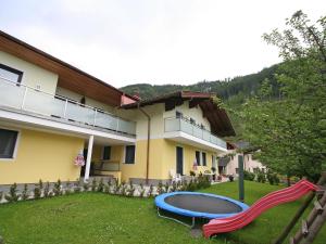 a house with a yard with a slide in front of it at Apartment Rosi-2 by Interhome in Werfenweng