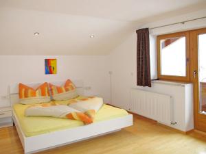 una camera da letto con un letto con cuscini arancioni e una finestra di Apartment Unterkreuter - KAB215 by Interhome a Kaltenbach