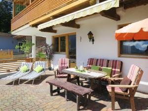een houten tafel en stoelen op een patio bij Apartment Hanser - MHO759 by Interhome in Schwentlberg
