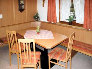 une table en bois avec deux chaises, une table et un fauteuil dans l'établissement Apartment Taxacher - ZAZ765 by Interhome, à Aschau