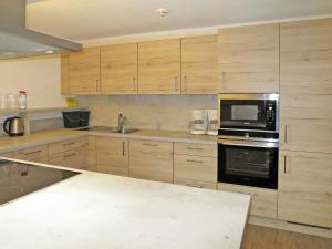 a kitchen with wooden cabinets and a black microwave at Chalet Talbach - MHO778 by Interhome in Laimach