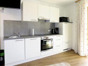 a kitchen with white cabinets and a sink at Apartment Lisi - SUZ372 by Interhome in Stummerberg