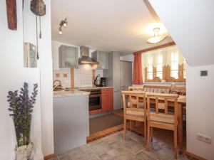 eine Küche mit einem Tisch und Stühlen sowie eine Küche mit einer Theke in der Unterkunft Apartment Beim Holzschnitzer-1 by Interhome in Sölden