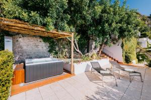 a garden with a hot tub and chairs on a patio at Villa Eris Amalfi Coast in Conca dei Marini