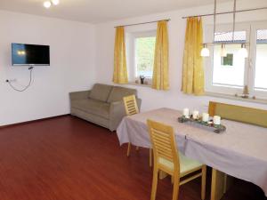 a living room with a table and a couch at Apartment Haus Huber - ZAZ403 by Interhome in Zell am Ziller