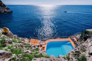 a swimming pool on the side of a body of water at Villa Eris Amalfi Coast in Conca dei Marini