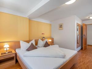 a bedroom with a large white bed with white pillows at Apartment Rosa-2 by Interhome in Mayrhofen