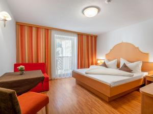 a bedroom with a bed and a red chair at Apartment Rosa-2 by Interhome in Mayrhofen +24 photos