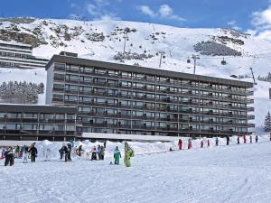 un grupo de personas en la nieve frente a un hotel en Apartment Aravis-3 by Interhome, en Les Menuires