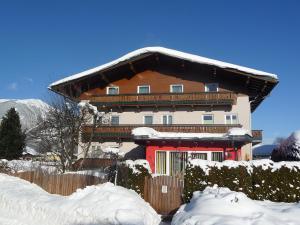 ein großes Haus mit einem schneebedeckten Dach in der Unterkunft Apartment Rupertus-4 by Interhome in Maishofen