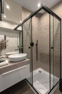 a bathroom with a glass shower and a sink at APARTIO ROOMS Katowice in Katowice