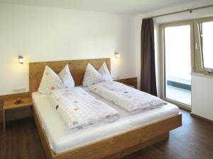 1 dormitorio con 1 cama grande y ventana grande en Apartment Anton - MHO561 by Interhome, en Ramsau im Zillertal