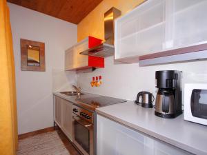 cocina con armarios blancos y fogones en Apartment Peter by Interhome, en Waidring