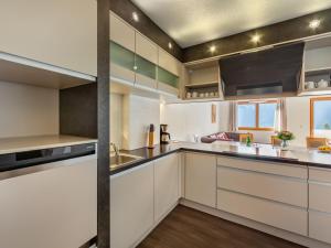 a kitchen with white cabinets and stainless steel appliances at Apartment Chalet Modern Life - MHO769 by Interhome in Ramsau im Zillertal