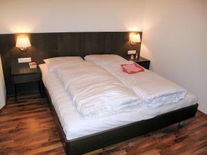 duże łóżko w pokoju z 2 stolikami nocnymi w obiekcie Apartment Wegscheider by Interhome w Mayrhofen