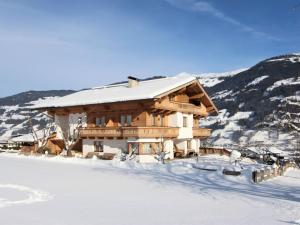 a log cabin in the snow with snow at Apartment Gasteighof-5 by Interhome in Kapfing