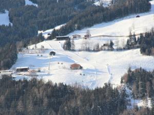 a snow covered hillside with houses and trees on it at Apartment Gasteighof-5 by Interhome in Kapfing +28 photos