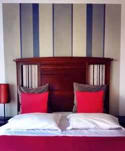 a bed with two red pillows in a room at Ay Home B&B in Bologna