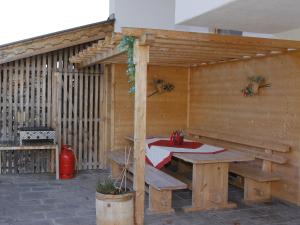 a wooden pavilion with a table and a picnic table at Apartment Gasteighof-5 by Interhome in Kapfing