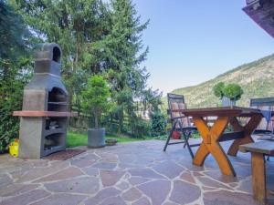 a patio with a pizza oven and a picnic table at Chalet Waldner by Interhome in Thannrain