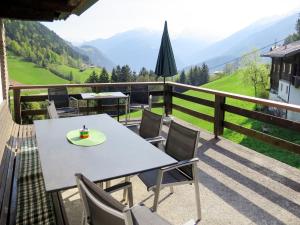 a table and chairs on a balcony with a view at Holiday Home Oberhaus by Interhome in Finkenberg