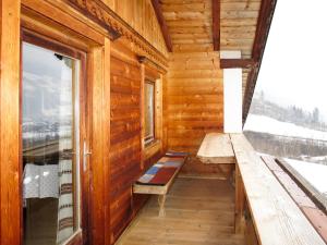 une véranda dans une cabane en bois avec un banc et une fenêtre dans l'établissement Holiday Home Baggenhof - MHO795 by Interhome, à Laimach