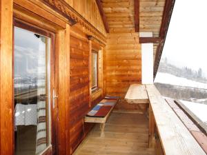 a porch of a wooden cabin with a bench and a window at Holiday Home Baggenhof by Interhome in Laimach