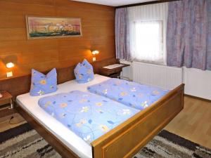 een slaapkamer met een groot bed met blauwe lakens bij Apartment Neumann - FBZ202 by Interhome in Finkenberg