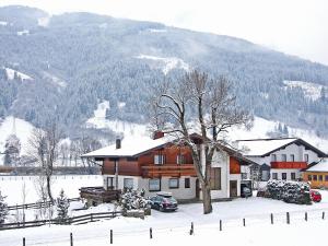 a house in the snow in front of a mountain at Apartment Haus Harlander by Interhome in Dorfgastein