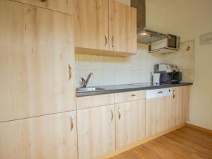 una cocina con armarios de madera y fregadero en Apartment Weinberg by Interhome, en Pettneu am Arlberg