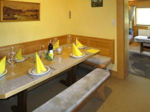 トゥクスにあるHoliday Home Häus'l - LNH250のダイニングルームテーブル(黄色のナプキン、ワイングラス付)