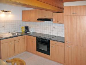 cocina con armarios de madera y horno con fogones en Apartment Hochwart - MHO353 by Interhome, en Brandberg