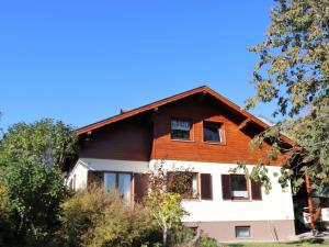 ein Haus auf einem Hügel mit Bäumen im Vordergrund in der Unterkunft Apartment Ennstalblick by Interhome in Weyern