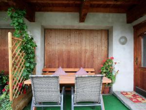 een houten tafel en stoelen voor een huis bij Apartment Gasteighof-4 by Interhome in Kapfing