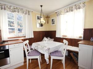 eine Küche mit einem Tisch, Stühlen und Fenstern in der Unterkunft Villa Marie-Sophie by Interhome in Mallnitz + 21 Fotos
