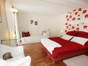 Schlafzimmer mit einem roten und weißen Bett und einem Sofa in der Unterkunft Villa Marie-Sophie by Interhome in Mallnitz